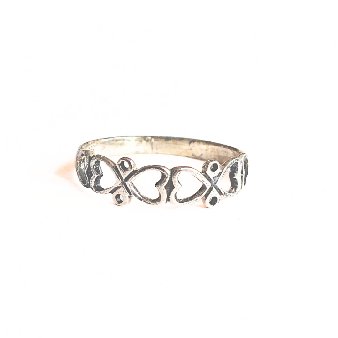Silver ring with intricate design on a white background