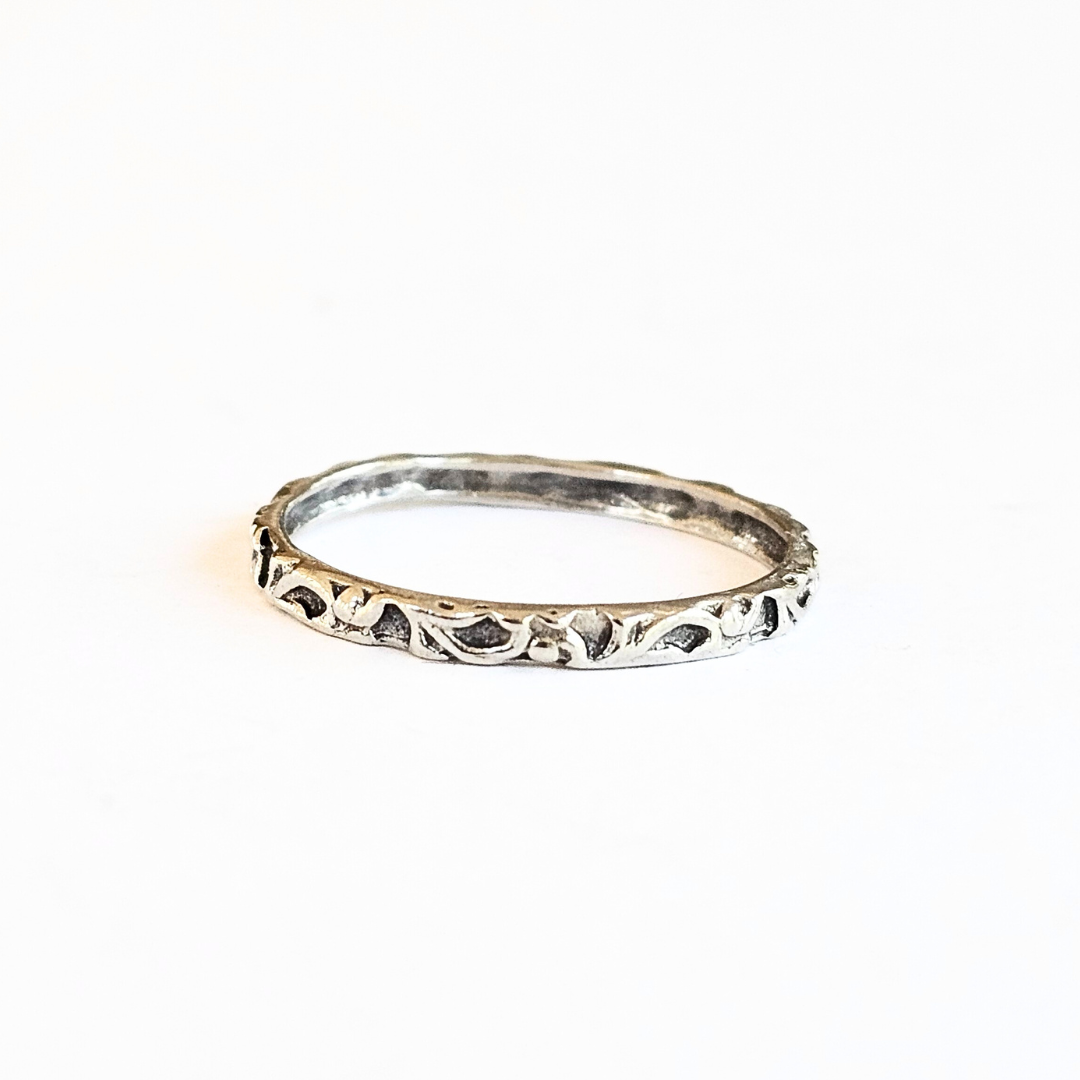 A Sterling Silver band ring with an intricate, thin pattern design, displayed on a white background.