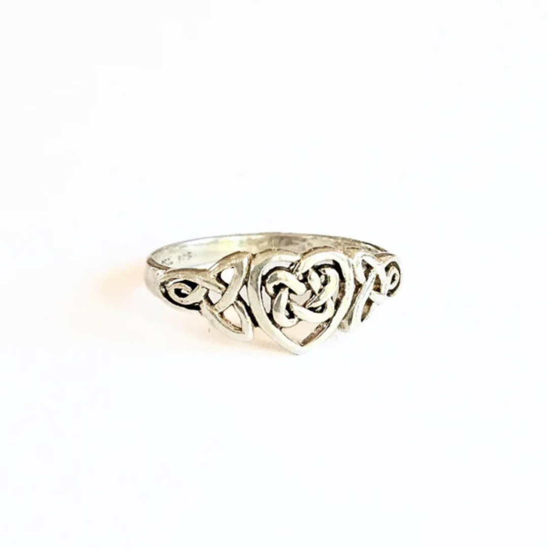 A Celtic Trinity Heart Ring with a detailed trinity knot design surrounding a central heart shape, crafted in sterling silver.