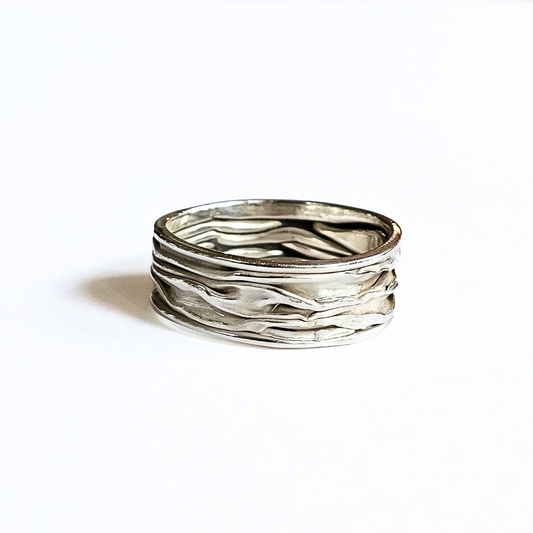 A silver ring with a wave-like design, featuring a band with multiple layers forming a circle.
