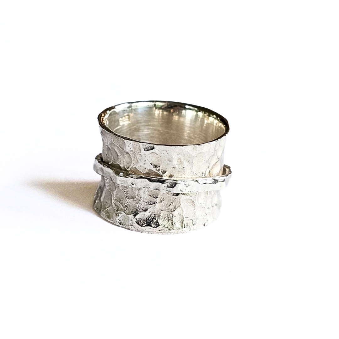 A sterling silver spinner ring with a textured surface and a rotating band, displayed against a white background.