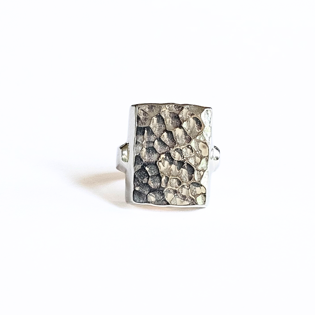A sterling silver hammered ring with a textured surface, displayed against a white background.