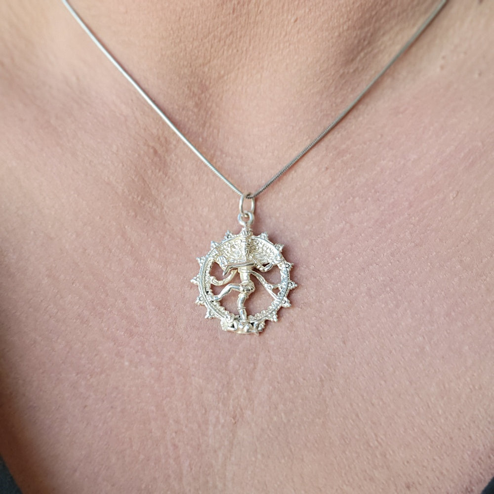 A sterling silver pendant depicting the figure of Nataraja, worn as a necklace.