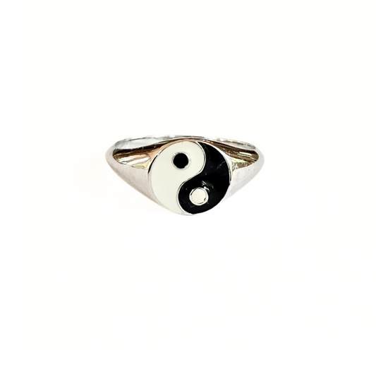 Silver ring with a black and white yin yang symbol on a white background